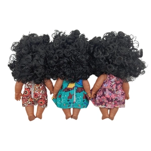 Detail of three black dolls featuring thick curly hair and colorful floral patterned dresses