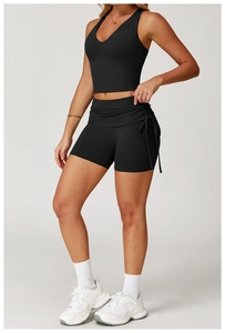 Detail of high-waisted black yoga shorts with side drawstring ruching and breathable fabric