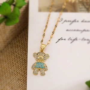 Detail of gold-plated bear pendant with white rhinestones and blue gemstone accent