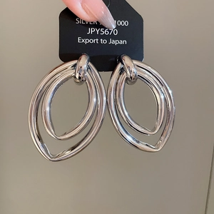 Gros plan détaillé de boucles d'oreilles créoles ovales multicouches en argent S925