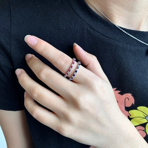 Close-up of stacked S925 sterling silver bands with colorful gemstone row setting