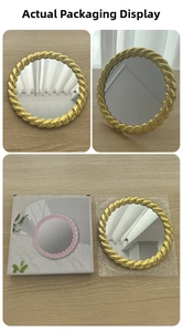 Detail of round gold vintage vanity mirror with rope frame and its original packaging