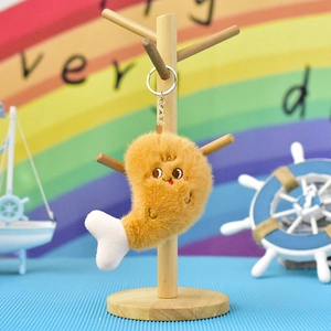Close-up of cute plush fried chicken leg keychain hanging on a wooden display stand