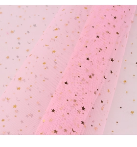 Close-up of pink mesh fabric with gold and silver foil star and moon patterns