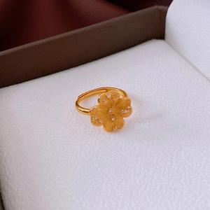 Gros plan sur une bague trèfle plaquée or sertie de zircons dans un coffret à bijoux chic