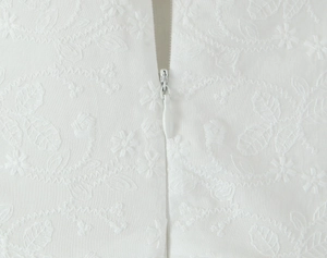 Vue macro de la fermeture éclair invisible et de la broderie en dentelle sur la robe