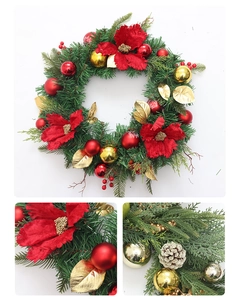 Detail view of artificial Christmas wreath with velvet poinsettias and festive ornaments