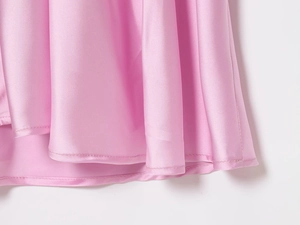 Macro detail of pink satin dress hem showing smooth fabric texture and precise stitching