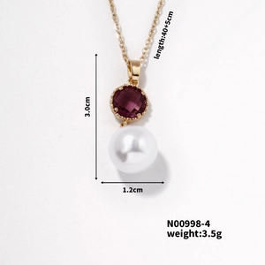 Détail macro du pendentif doré avec pierre violette, perle blanche et mesures précises