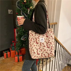 Floral corduroy tote bag for women shown on model in a cozy indoor setting