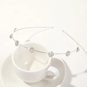 Detail shot of silver leaf headband with seven sparkling rhinestone flowers on a cup