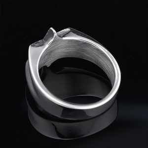 Detailed close-up of a silver stainless steel hexagram ring on a black reflective surface