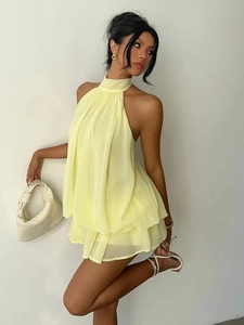Detail of light yellow halter chiffon dress with tiered ruffles and open back design
