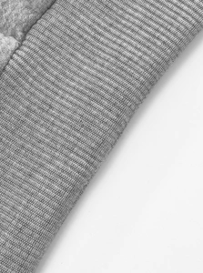 Macro shot of grey ribbed knit texture showing premium fabric details on cuff and hemline