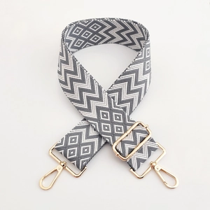 Detail of grey wave pattern adjustable shoulder strap with gold metal buckles