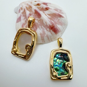 Detailed macro view of 18K gold-plated baroque rectangle pendants with natural abalone shells