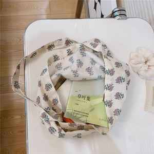 Close-up of floral cotton tote bag with purple flowers and books inside