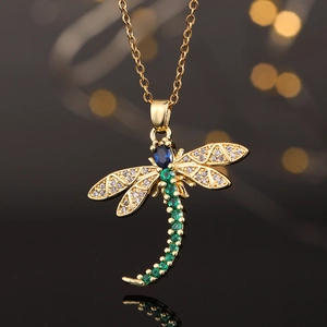 Macro shot of dragonfly pendant necklace with blue sapphire and green cubic zirconia stones