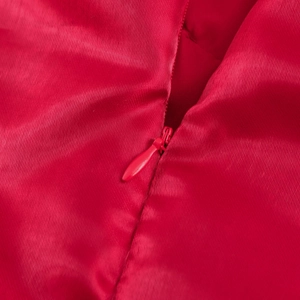Détail d'une robe courte bouffante rouge avec fermeture éclair invisible et texture satinée