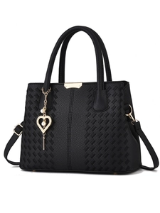Détail du sac à main noir en similicuir avec texture grainée et pendentif perle cœur