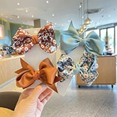 Set of four large fabric hair bows featuring floral and solid patterns for children