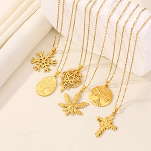 Close-up of golden stainless steel pendants including snowflake and tree of life styles