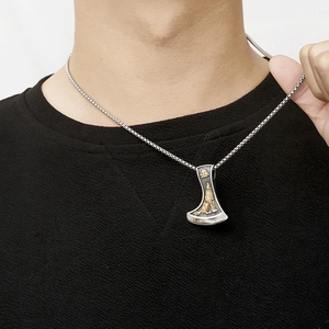 Détail du pendentif hache viking punk avec loup doré sur une chaîne en acier robuste