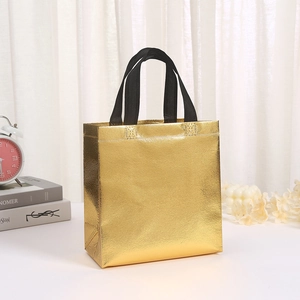 Dettaglio di borsa shopper dorata in pellicola laser non tessuta con manici neri