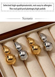 Macro shot of gold and silver teardrop earrings in a velvet display box, high polish finish