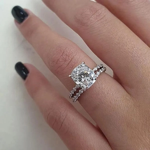 Close-up of cushion cut diamond engagement ring and matching pavé wedding band set