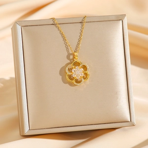 Elegant gold flower pendant necklace with zircon crystals on champagne silk background
