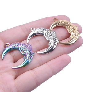 Close-up of stainless steel moon and rose pendants in rainbow, silver and gold finishes