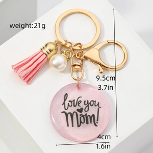 Détail du porte-clés à pompon rose avec breloque MOM et perle montrant les dimensions