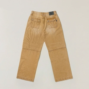 Detail of vintage workwear pants showing back pockets and leather cross emblem patch