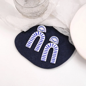 Detail of blue and white patterned U-shaped earrings with artistic porcelain texture