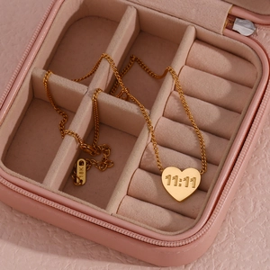 Detailed view of 18K gold plated heart pendant with 11:11 engraving on pink velvet