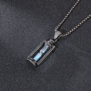 Close-up of vintage hourglass necklace with blue sand and S925 engraved sterling silver clasp