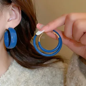 Minimalist Klein blue hoop earrings in wide C-shape and round ring styles with gold pins