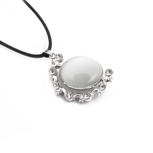 Detail of silver star and moon pendant with white cat eye stone and black cord