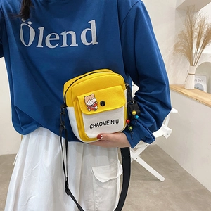 Japanese style yellow canvas crossbody bag with cartoon badge and black shoulder strap