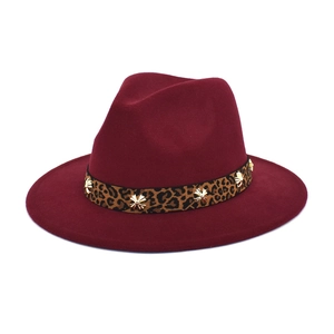 Detail of burgundy fedora hat with leopard print band and gold star metal rivets