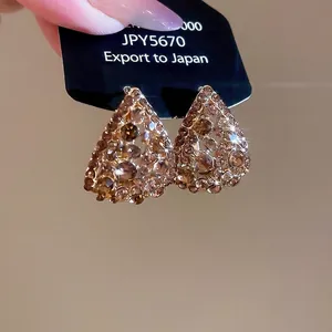 Sparkling pear-shaped drop earrings featuring champagne pavé rhinestones in a luxury style