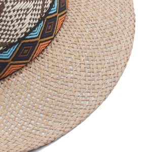 Detail of woven straw hat featuring a colorful ethnic geometric pattern ribbon band