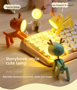 Mini animal-shaped LED night lights with movable joints used as phone stands on a keyboard