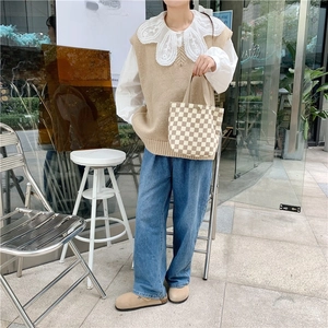 Detail shot of corduroy checkered tote bag styled with a vintage aesthetic casual outfit
