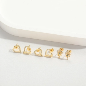 Three-piece set of gold heart and cross stud earrings with clear and blue gems