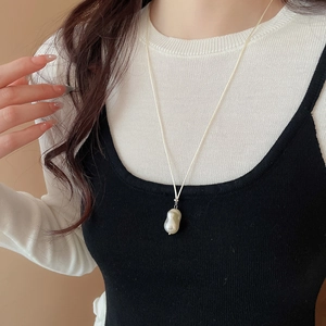 Detailed view of an irregular baroque pearl pendant on a minimal long cord necklace