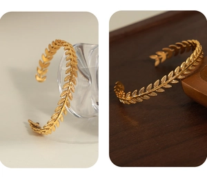 Macro detail of golden laurel leaf cuff bracelet showing intricate engraved textures