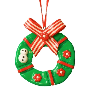 Green Christmas wreath ornament with a red bow, snowman detail, and a hanging string