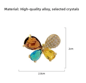 Detailed macro view of a crystal butterfly brooch with amber, blue and yellow stones